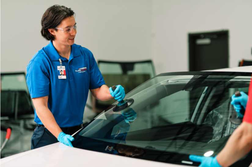 Two male Glass Doctor service professionals using tools to replace a windshield.